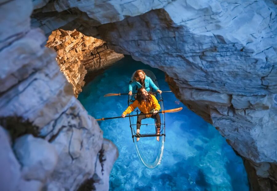 Pula: Night-Time Sea Kayaking Tour in Transparent Kayak - Entering the small cave by glowing kayak
