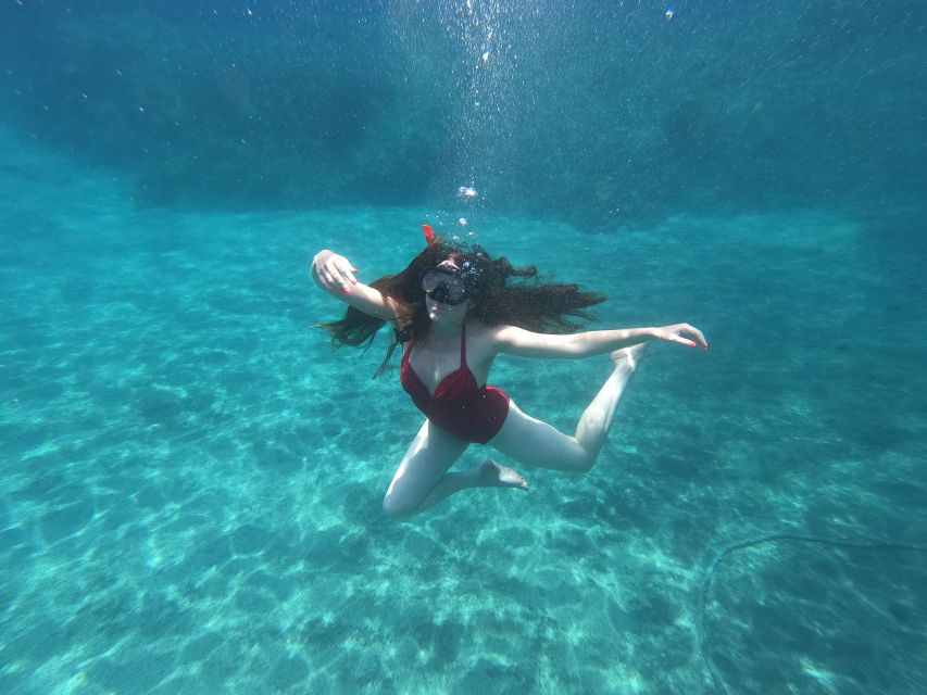 Santorini: Sea Caves Kayak Trip with Snorkeling and Picnic - Black Mountain, clear water, and snorkeling